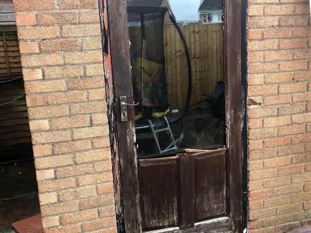 Before: A back door beyond saving, rotten and split, renewed with a secure UPVC door.