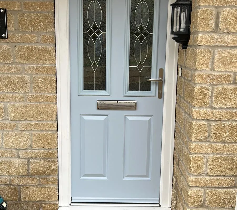 Duck-egg blue composite front door with decorative glazing, fitted by Window And Door Doctor