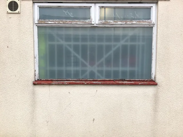 Before: Rotten timber window on a commercial unit, replaced with a new double glazed UPVC window.
