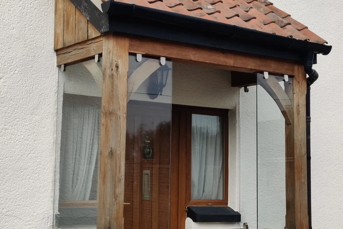 Frameless glass panels fitted to an oak-framed porch by Window And Door Doctor